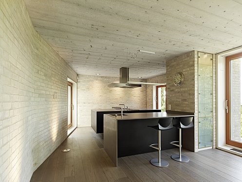 moderne Küche mit Bar und Steinwand 